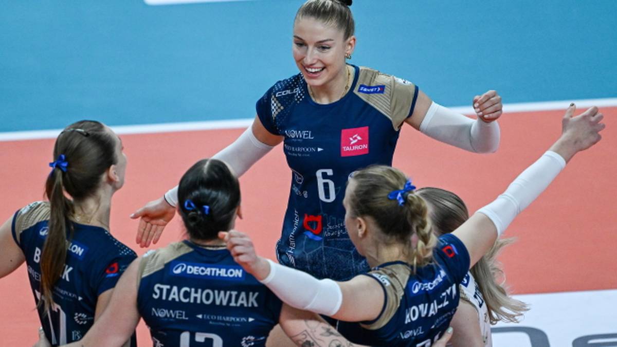 Grupa siatkarek DevelopRes Rzeszów świętuje zwycięstwo, jedna z zawodniczek trzyma ręce w górze.