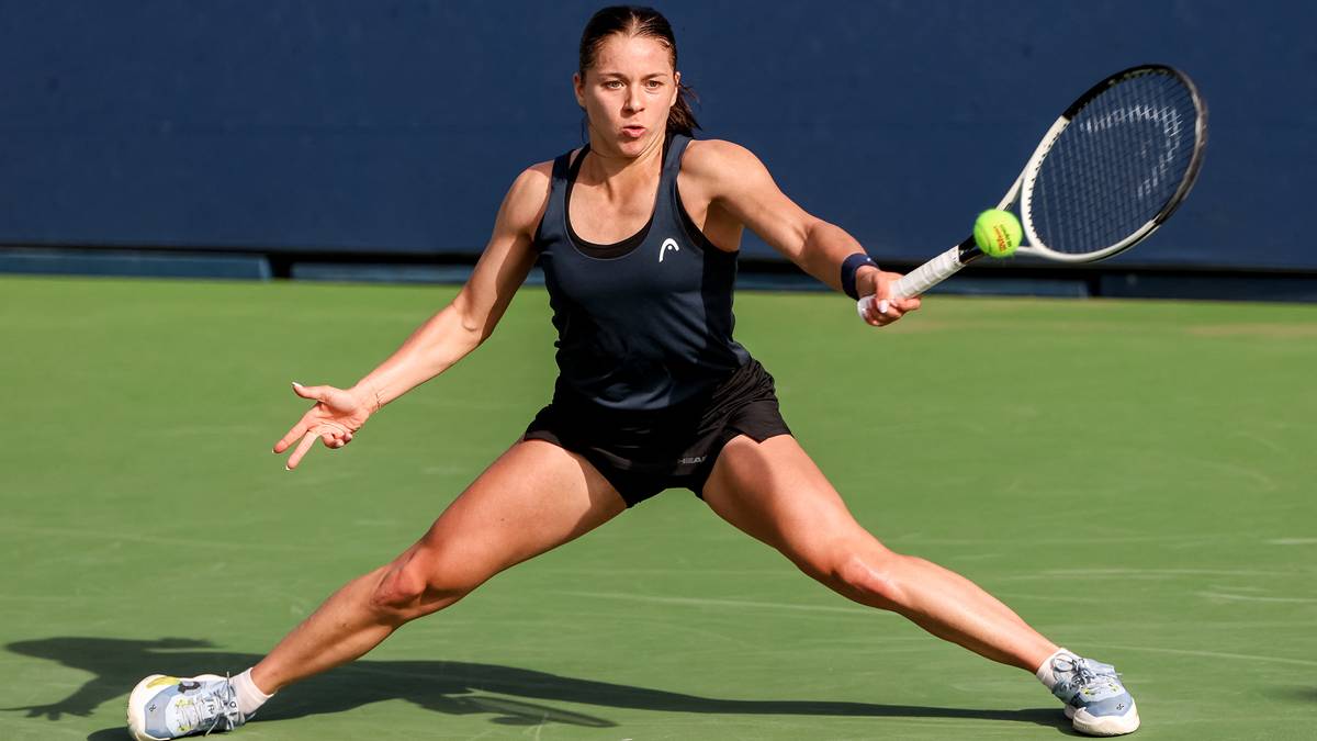 Polska tenisistka w pozycji do uderzenia rakietą, na korcie tenisowym.