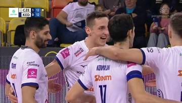 Siatkarze w białych koszulkach celebrują zdobyty punkt, obejmując się nawzajem.