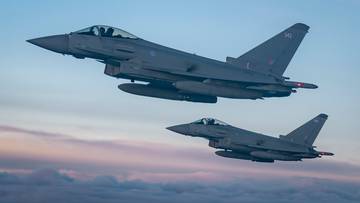 Dwa myśliwce Eurofighter Typhoon FGR4 lecące na tle nieba o zachodzie słońca.