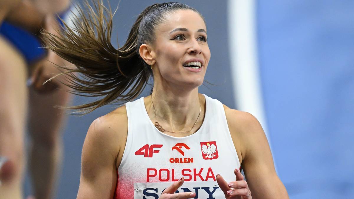Kobieta w białej koszulce z napisem "POLSKA" biegnie podczas zawod&oacute;w lekkoatletycznych.