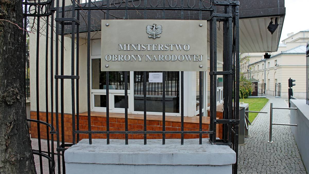 Tablica z napisem Ministerstwo Obrony Narodowej na metalowej bramie wejściowej do budynku.