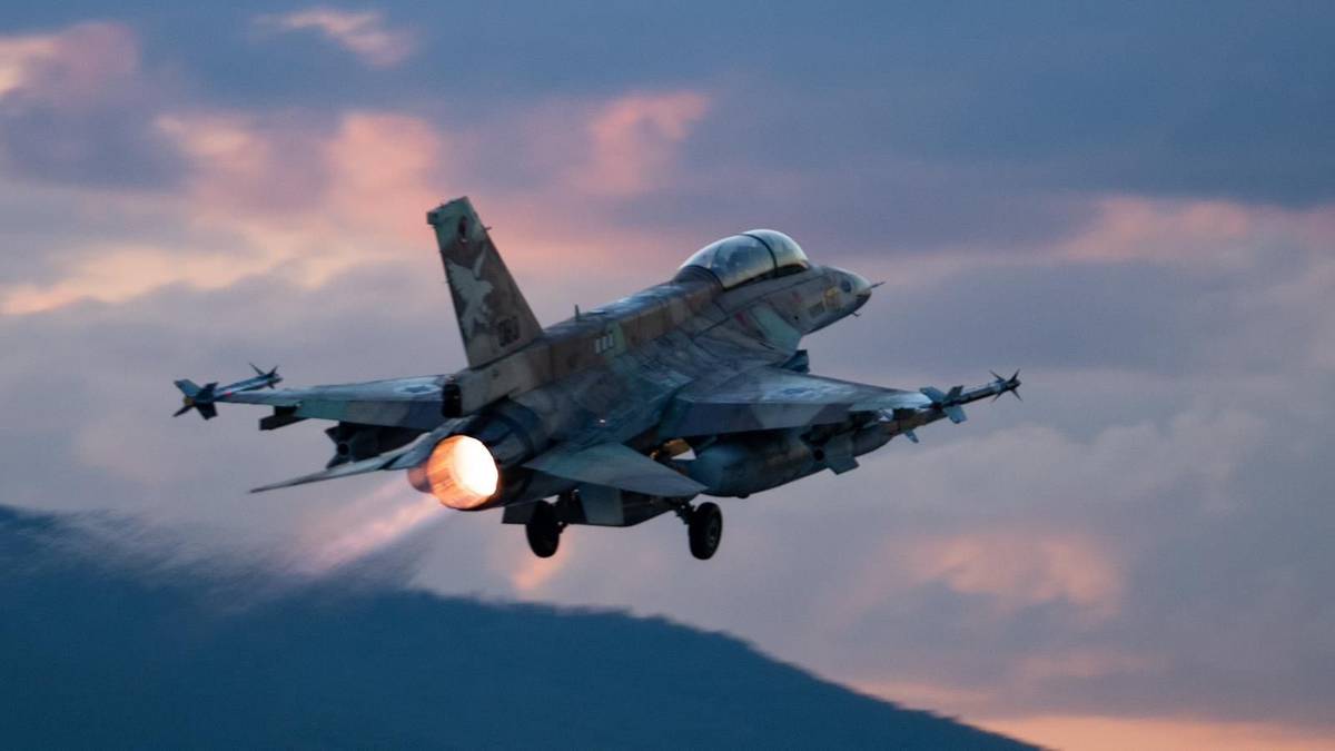 Myśliwiec wojskowy startujący na tle zachodzącego słońca i chmur.