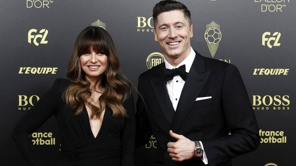 Robert Lewandowski i Anna Lewandowska pozują na czerwonym dywanie w eleganckich strojach.