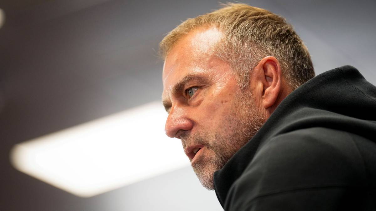 Portret Hansiego Flicka, trenera piłkarskiego, w zbliżeniu, uchwycony z profilu. Widoczny jego poważny wyraz twarzy i siwe włosy.