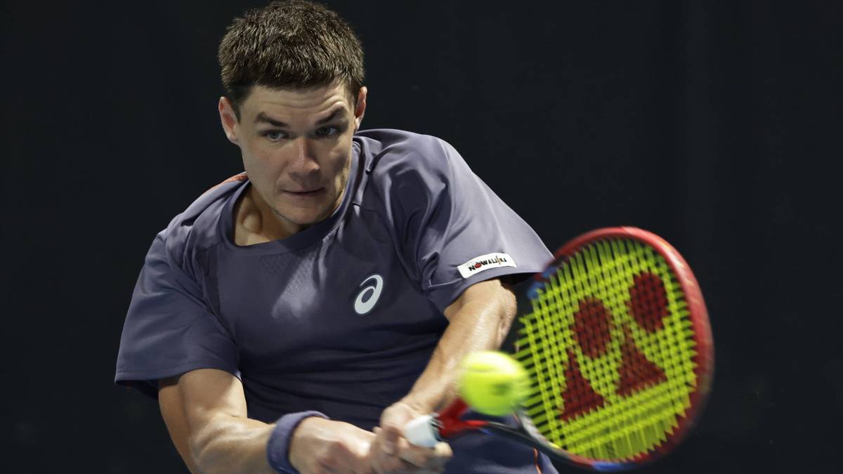 Tenisista uderza piłkę rakietą podczas meczu.