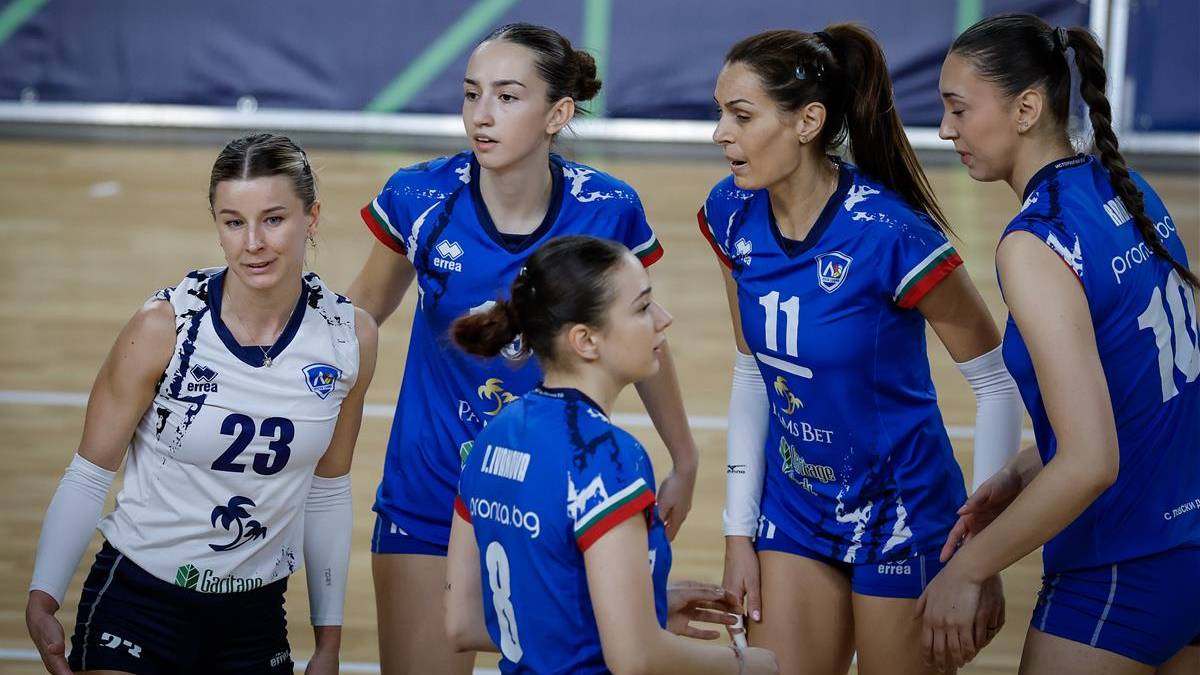 Pięć siatkarek w strojach sportowych podczas meczu siatk&oacute;wki.