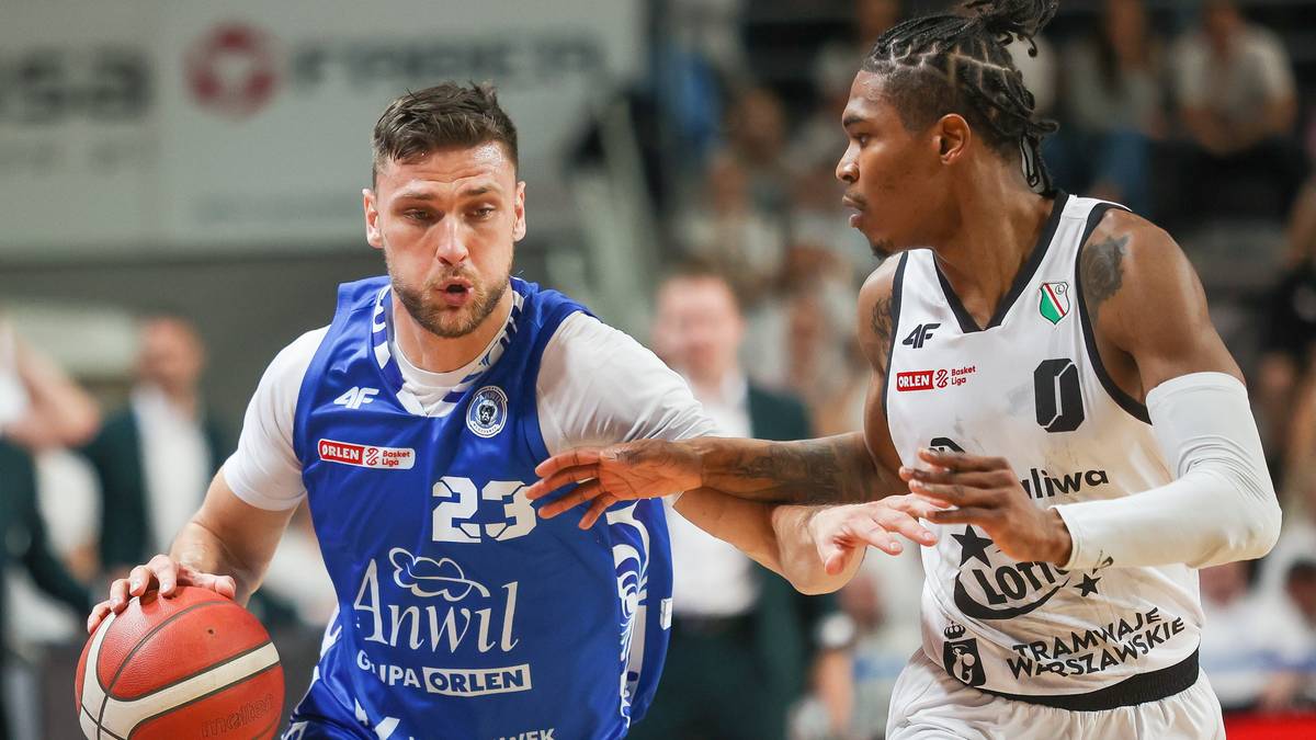 Dwóch zawodników koszykówki podczas meczu. Jeden w niebieskiej koszulce z numerem 23 próbuje poprowadzić piłkę, a drugi w białej koszulce próbuje go zatrzymać.