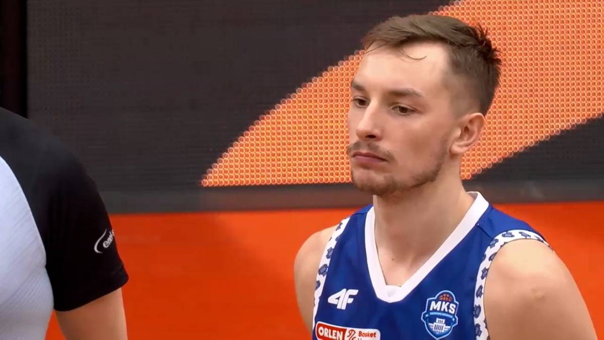 Koszykarz MKS Dąbrowa Górnicza w niebieskiej koszulce z białymi wstawkami.