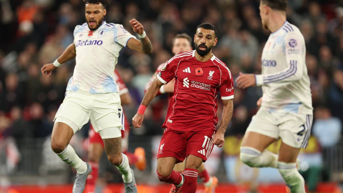 Piłkarze Liverpoolu w akcji podczas meczu, jeden z nich prowadzi piłkę, a dwaj przeciwnicy próbują ją odebrać.