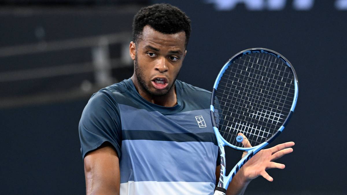 Tenisista z rakietą w ręku, przygotowujący się do odbicia piłki tenisowej.