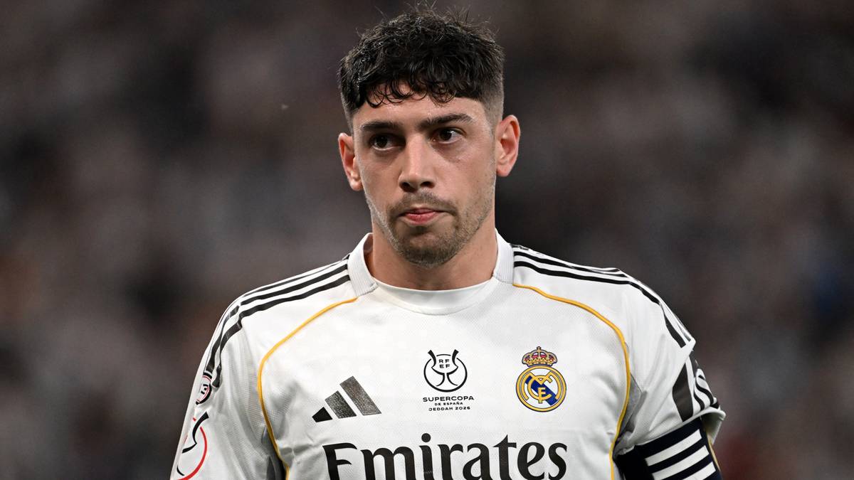 Piłkarz Realu Madryt w białej koszulce meczowej z widocznym logo sponsora, z czarną opaską na ramieniu.