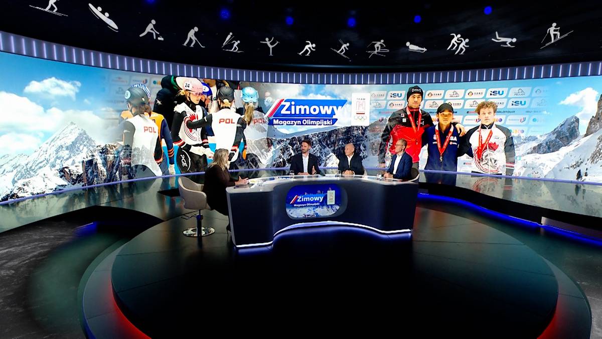 Trzy osoby siedzą za biurkiem w studiu telewizyjnym z ekranem w tle przedstawiającym sporty zimowe i logo "Zimowy".