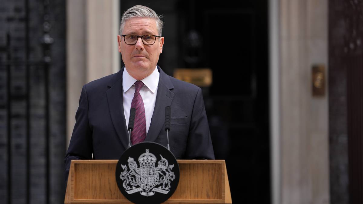 Keir Starmer przemawiający za mównicą przed budynkiem Downing Street 10, z herbem Wielkiej Brytanii na mównicy.