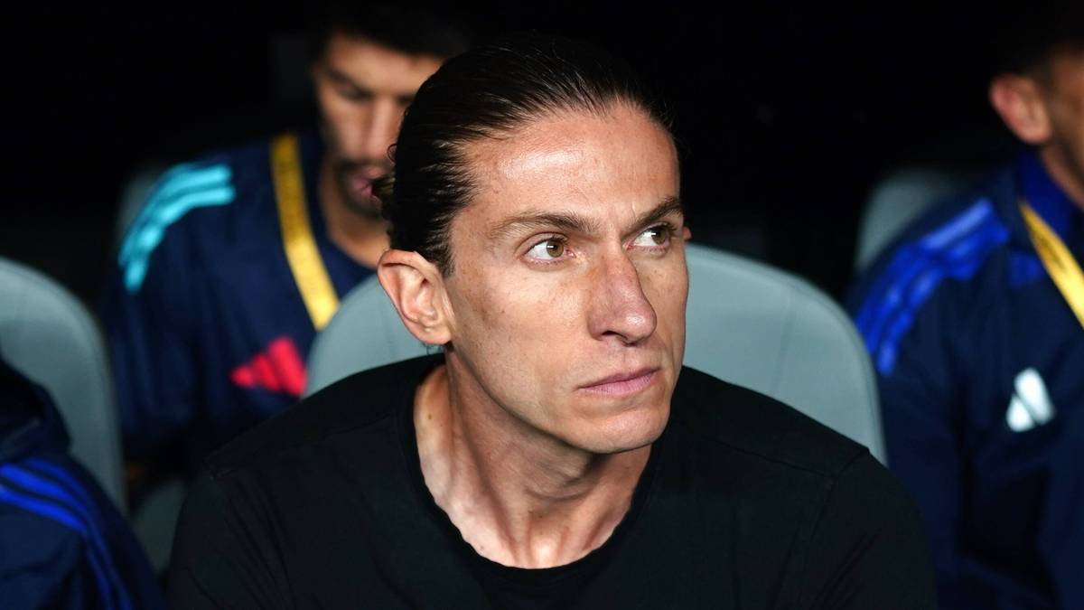 Filipe Luis siedzący na ławce trenerskiej, ubrany w czarny t-shirt.