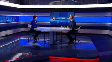 Dwie osoby siedzą przy okrągłym stole w studiu telewizyjnym. Na ekranie za nimi widnieje logo stacji i napis "Gość Wydarzeń".
