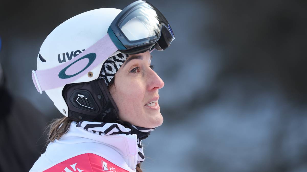 Portret kobiety w kasku narciarskim i goglach, patrzącej w bok z uśmiechem.