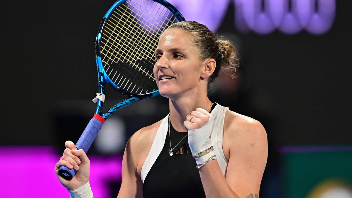 Kobieta tenisistka z rakietą w ręce, przygotowana do uderzenia.