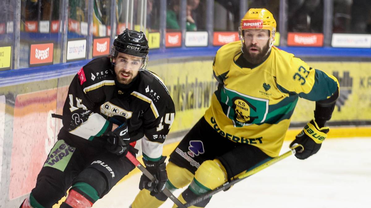 Dwóch hokeistów rywalizujących o krążek na lodowisku podczas meczu.