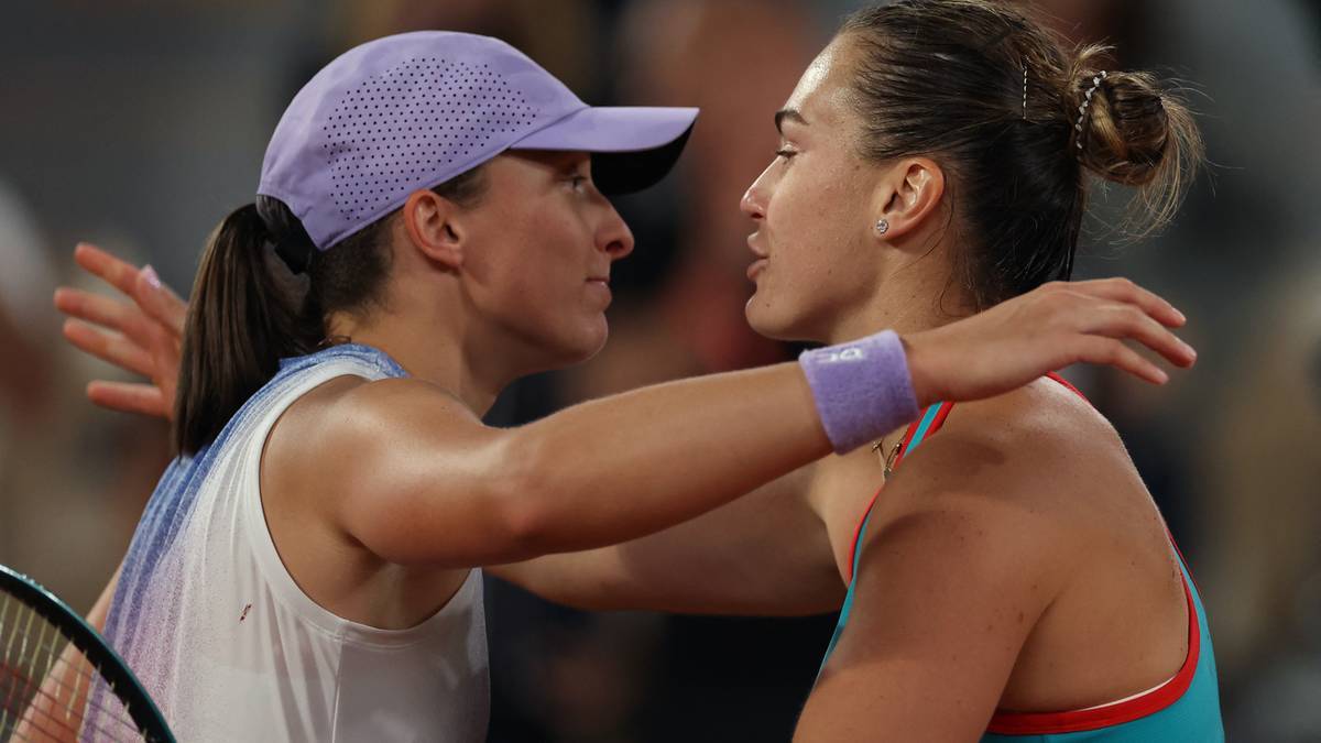 Iga Świątek i Aryna Sabalenka patrzą na siebie, zbliżając się do siebie.