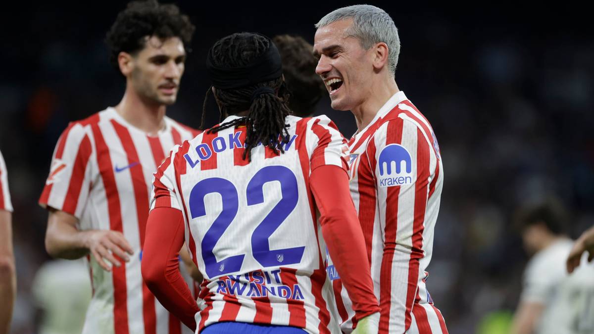 Piłkarze Atletico Madryt w strojach meczowych, jeden z nich uśmiecha się.