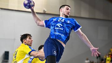 Piłkarz ręczny w niebieskiej koszulce z numerem 24 i logo Orlen celuje do rzutu.