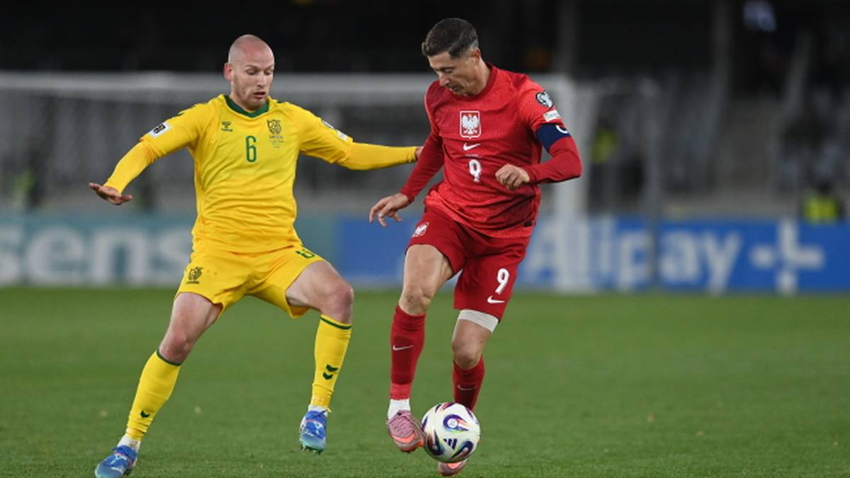 Piłkarz w czerwonej koszulce z numerem 9, Robert Lewandowski, próbuje odebrać piłkę piłkarzowi w żółtej koszulce.