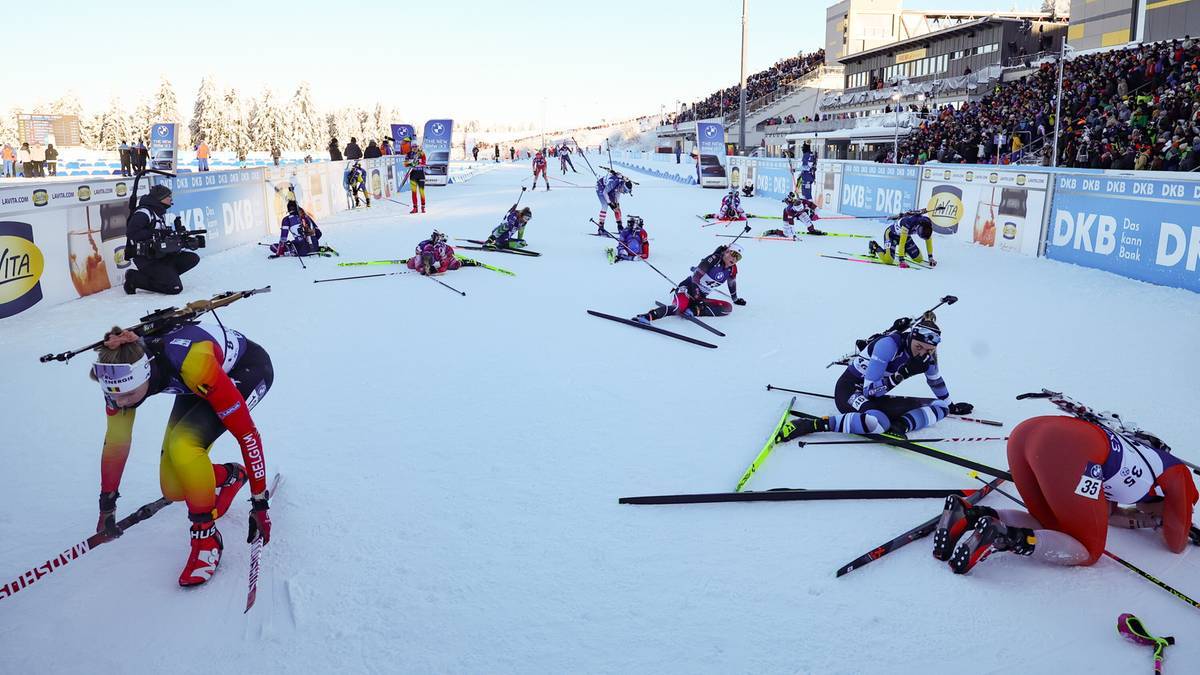 Biathloniści rywalizujący na śnieżnym torze, niekt&oacute;rzy upadli.