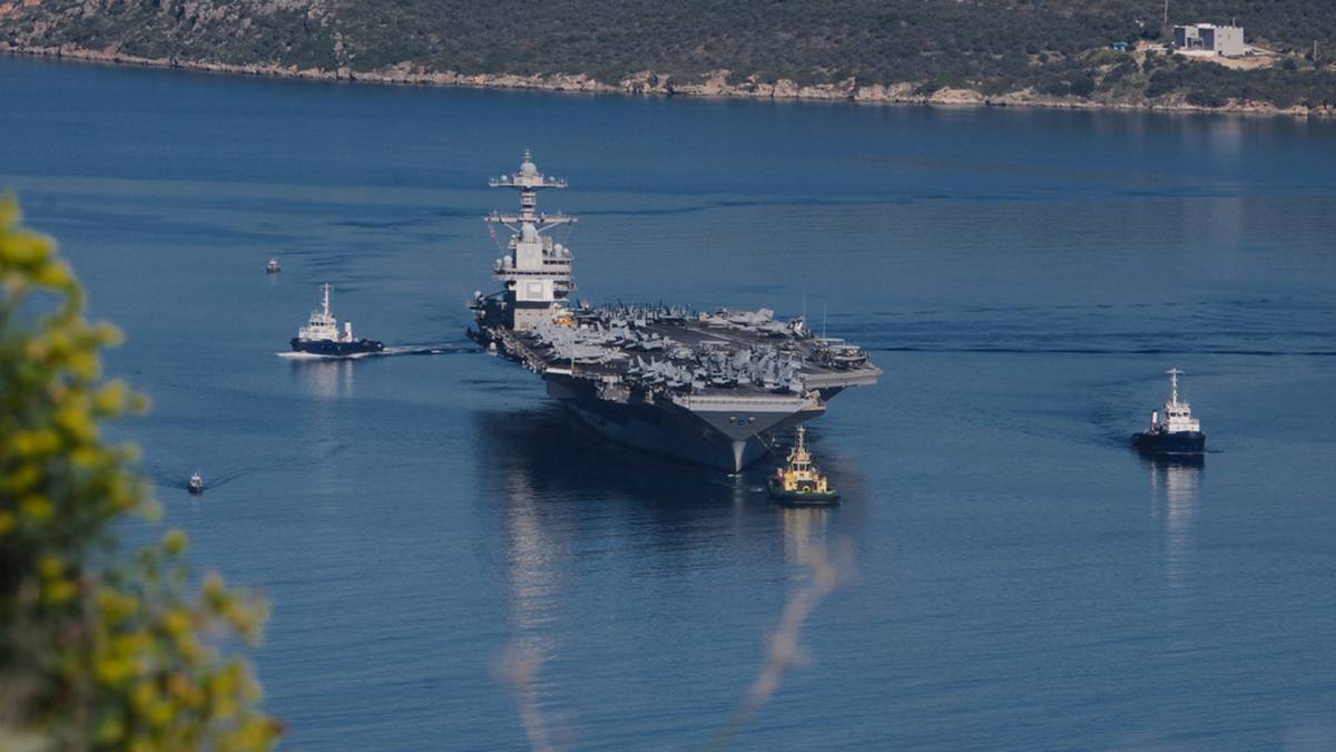 Lotniskowiec USS Gerald R. Ford z holownikami wchodzący do portu.