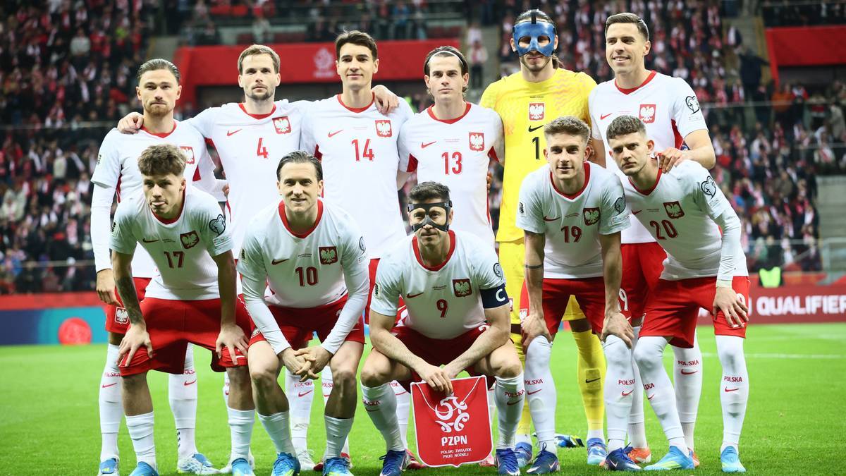 Reprezentacja Polski w piłce nożnej pozuje do zdjęcia w strojach meczowych.