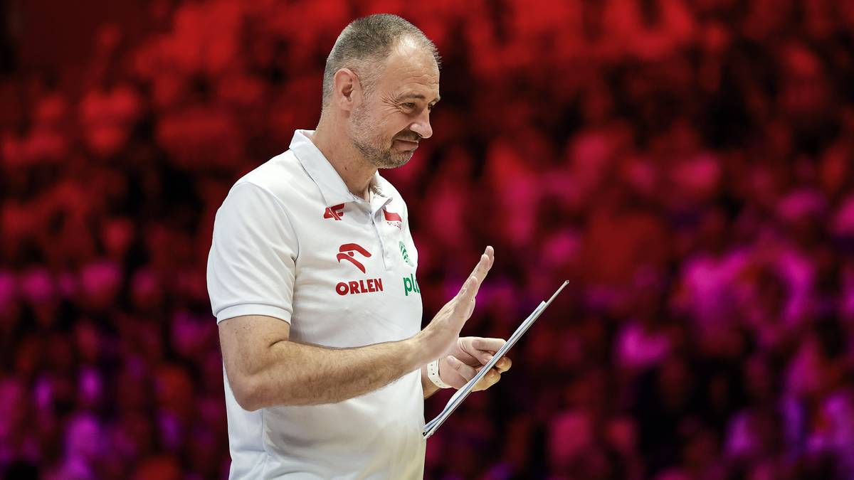 Trener reprezentacji Polski w siatkówce Nikola Grbić stoi na tle trybun trzymając kartkę.