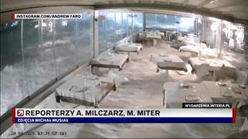 Wnętrze restauracji po przejściu cyklonu, ze zniszczonymi stołami i krzesłami.