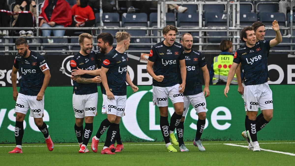 Piłkarze drużyny Viking Stavanger w strojach meczowych stoją na boisku.