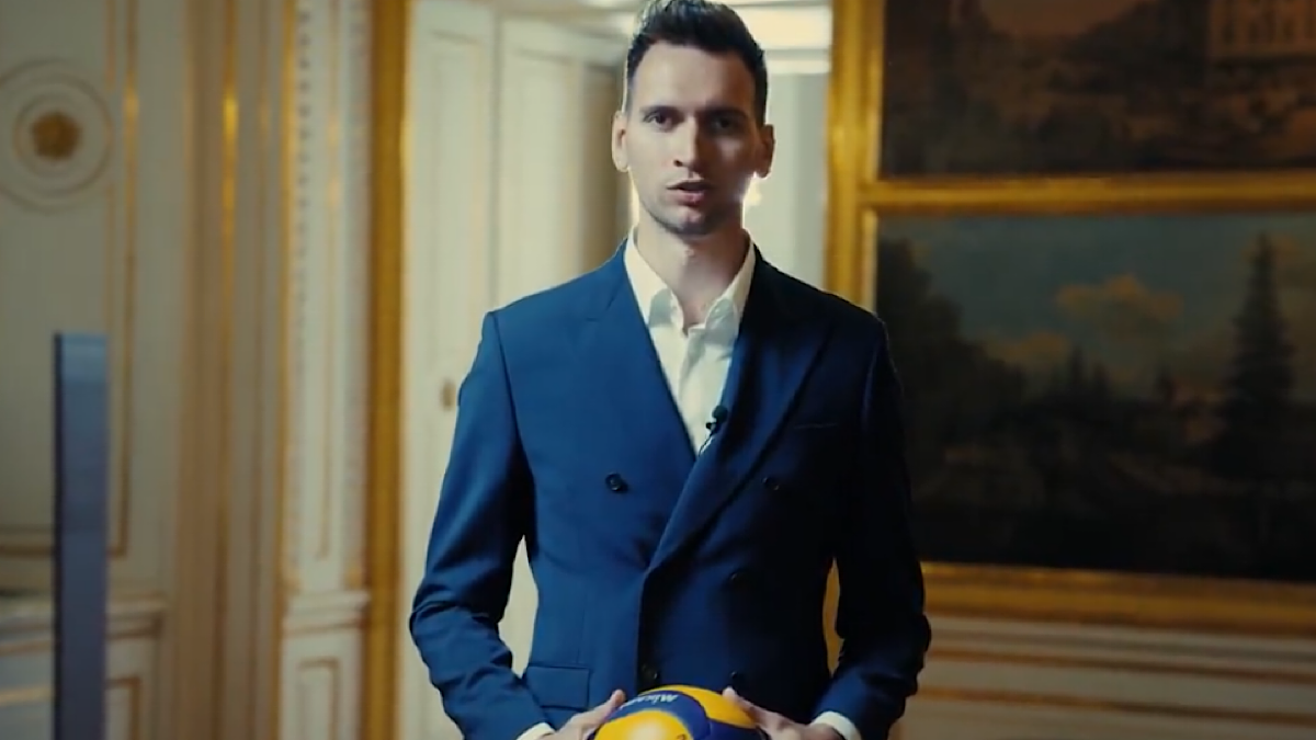 Yuri Romano, siatkarz PGE Projektu Warszawa, trzyma piłkę do siatk&oacute;wki w eleganckim stroju.