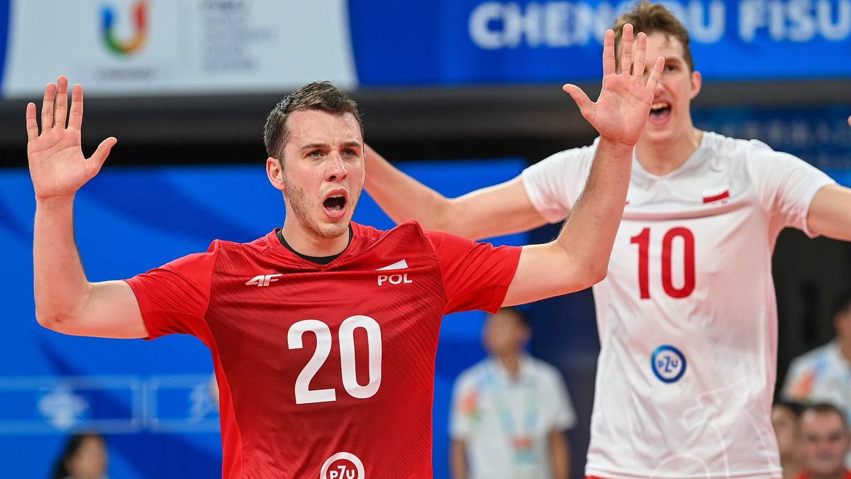 Dwaj siatkarze w strojach reprezentacji Polski, jeden w czerwonej koszulce z numerem 20, drugi w białej z numerem 10, unoszą ręce w geście radości.