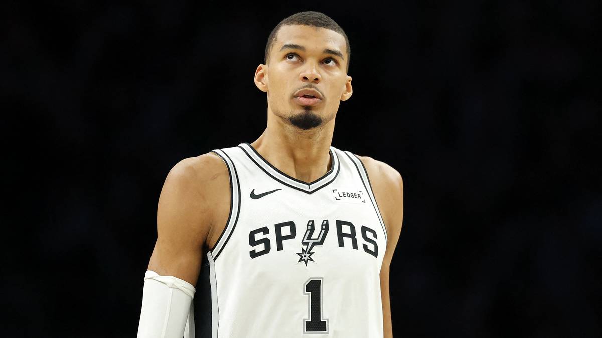 Koszykarz Victor Wembanyama w stroju San Antonio Spurs z numerem 1 na koszulce, patrzy w g&oacute;rę.