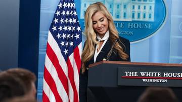 Nowa rzeczniczka Białego Domu Katie Zacharia podczas konferencji prasowej stojąca za m&oacute;wnicą z napisem The White House