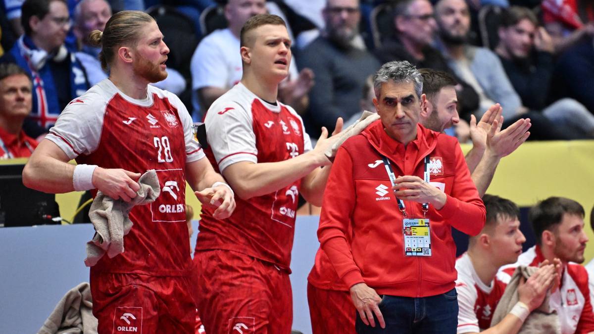 Piłkarze ręczni reprezentacji Polski w czerwonych strojach, wraz z trenerem, podczas meczu.