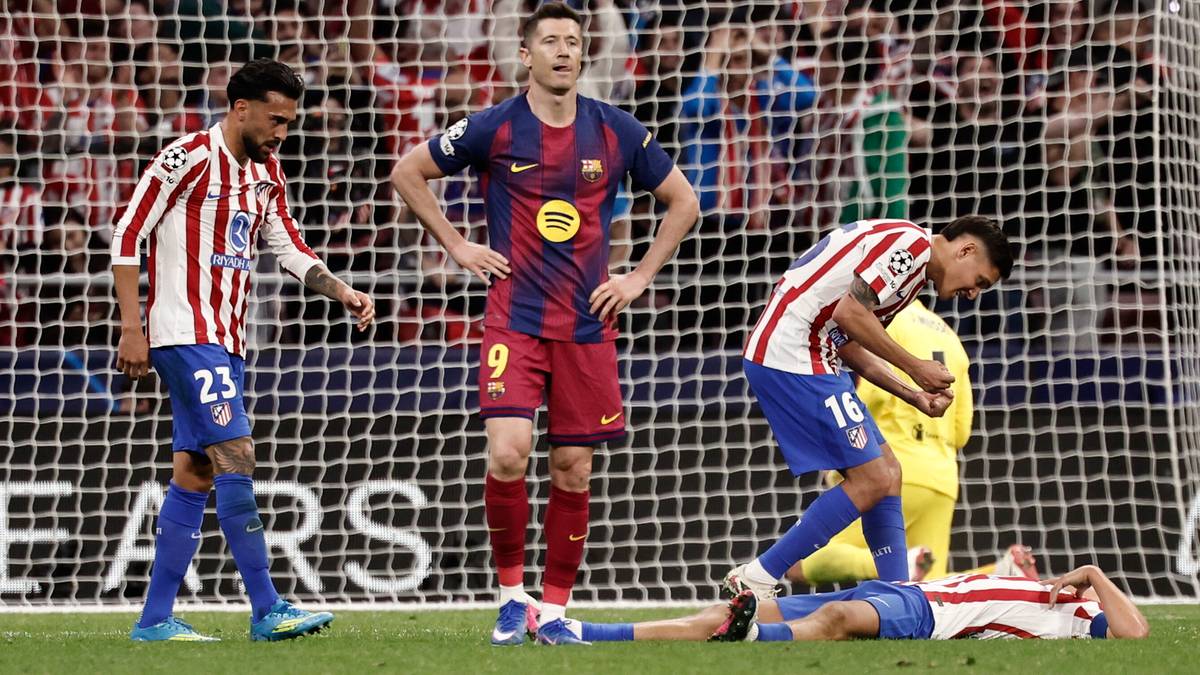 Piłkarze FC Barcelona i Atletico Madryt na murawie po meczu, jeden z zawodnik&oacute;w leży na ziemi.