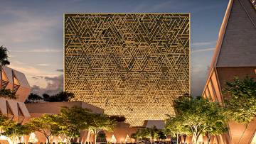 Wizualizacja futurystycznego, złotego, sześciennego budynku Mukaab z geometrycznym wzorem na fasadzie, otoczonego nowoczesną architekturą i drzewami.