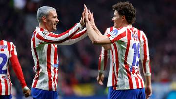 Dw&oacute;ch piłkarzy Atletico Madryt w biało-czerwonych strojach podaje sobie piątkę, świętując na boisku.