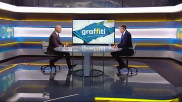 Dw&oacute;ch mężczyzn siedzi naprzeciwko siebie w studiu telewizyjnym. Na środkowym ekranie widnieje napis "graffiti".
