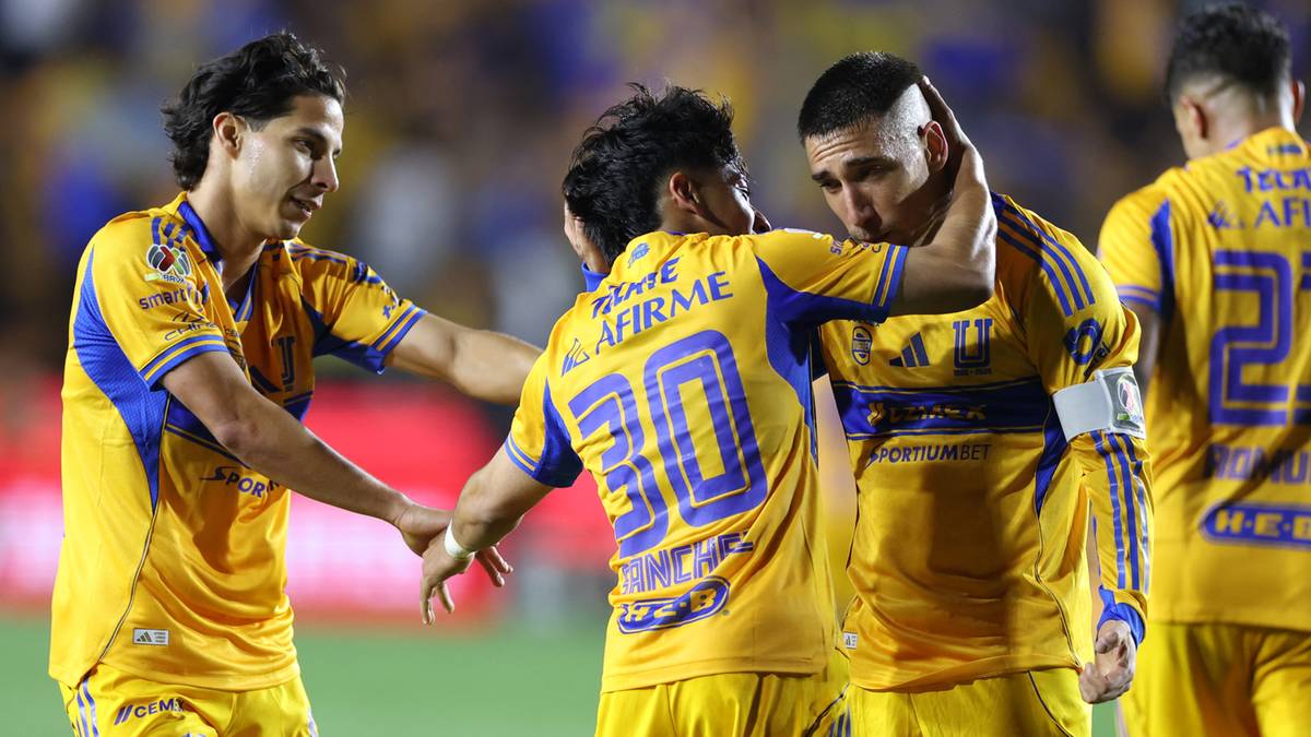 Piłkarze Tigres w ż&oacute;łtych strojach świętują bramkę, obejmując się na boisku.