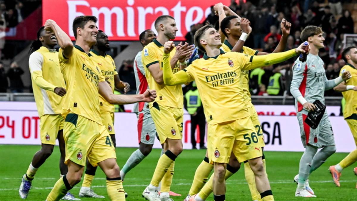 Piłkarze Milanu w żółtych strojach świętują zwycięstwo na boisku.