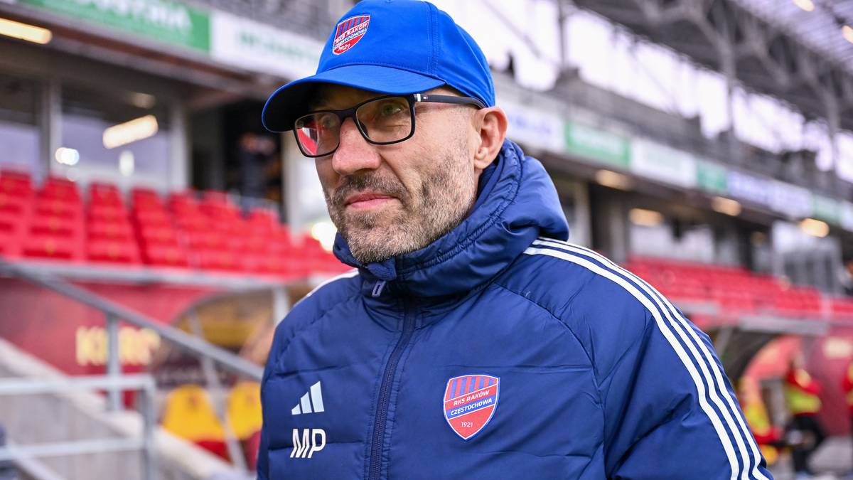 Marek Papszun w czapce i kurtce sportowej na tle stadionu.