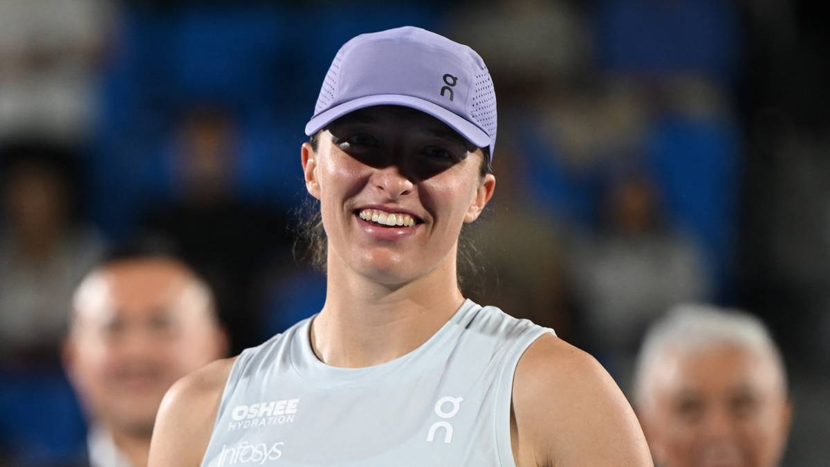 Iga Świątek uśmiecha się do obiektywu.