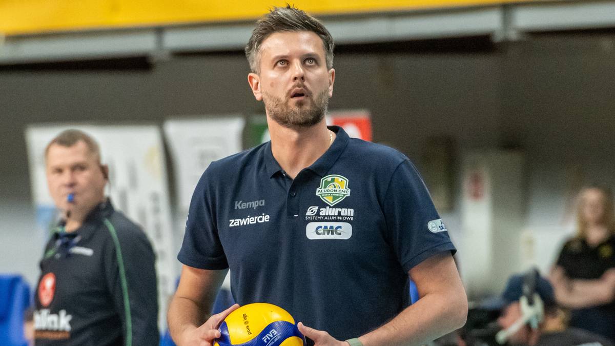 Michał Winiarski, trener siatkarskiej drużyny Aluron CMC Warta Zawiercie, trzyma piłkę siatkową.