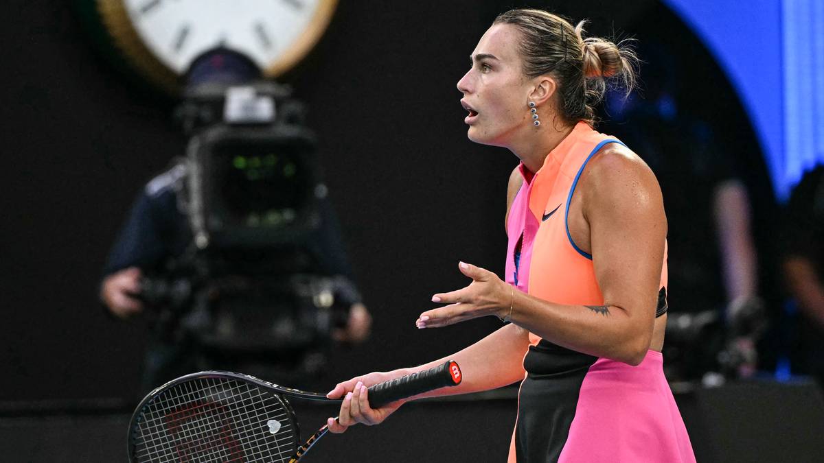 Aryna Sabalenka trzyma rakietę tenisową i gestykuluje prawą ręką, wyrażając emocje na korcie.