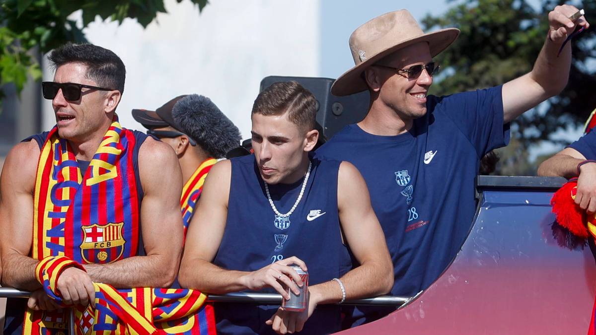 Trzej młodzi mężczyźni w strojach piłkarskich, prawdopodobnie zawodnicy FC Barcelony, podczas celebrowania zwycięstwa.