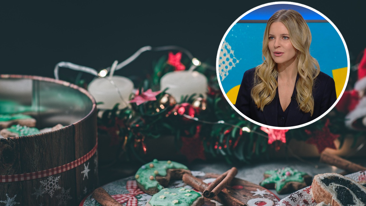 Zbliżenie na świąteczne pierniczki ozdobione lukrem i posypką, obok puszka z ciastkami i wianek adwentowy ze świecami. W prawym g&oacute;rnym rogu miniatura z portretem uśmiechniętej kobiety.